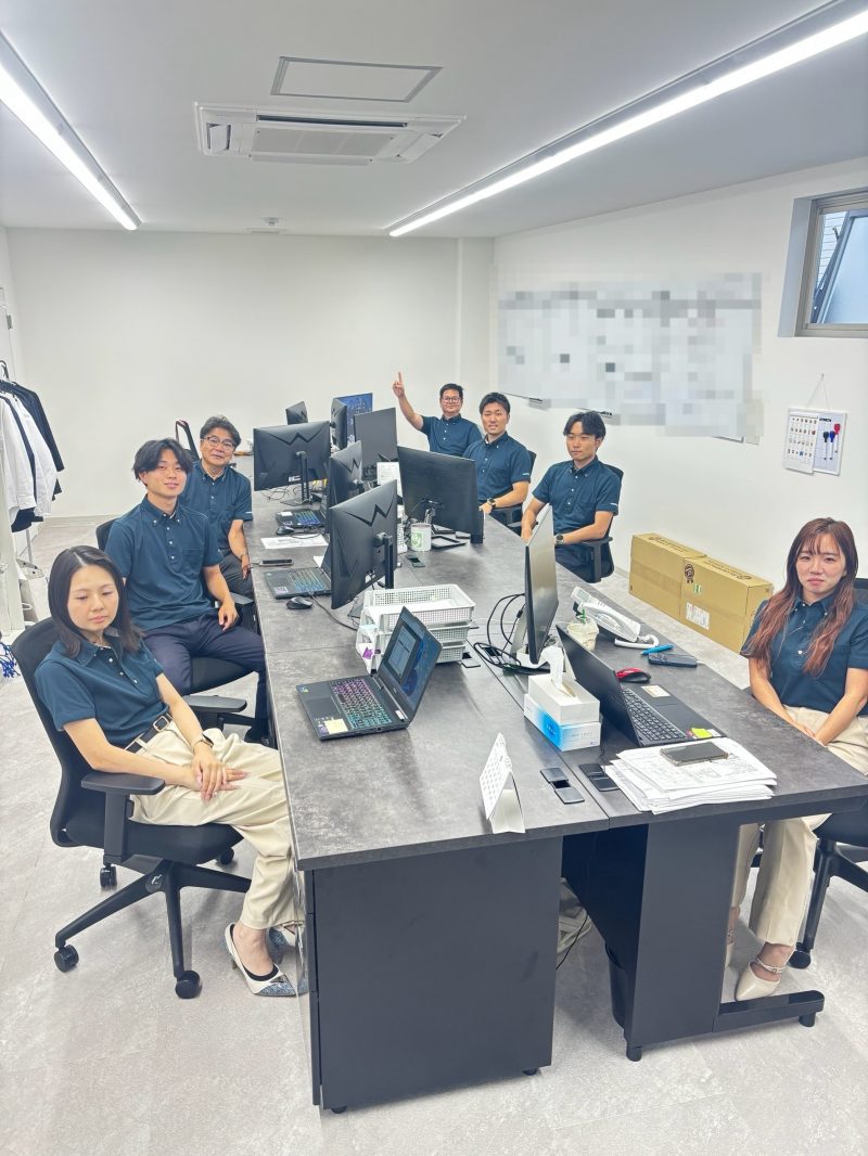 事務所で働くスタッフ7名。おそろいのポロシャツ